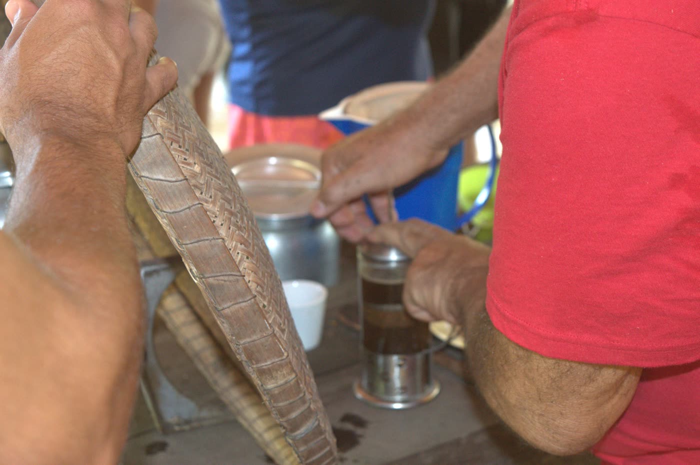 Preparo do café na prensa, com a peneira de palha ao lado