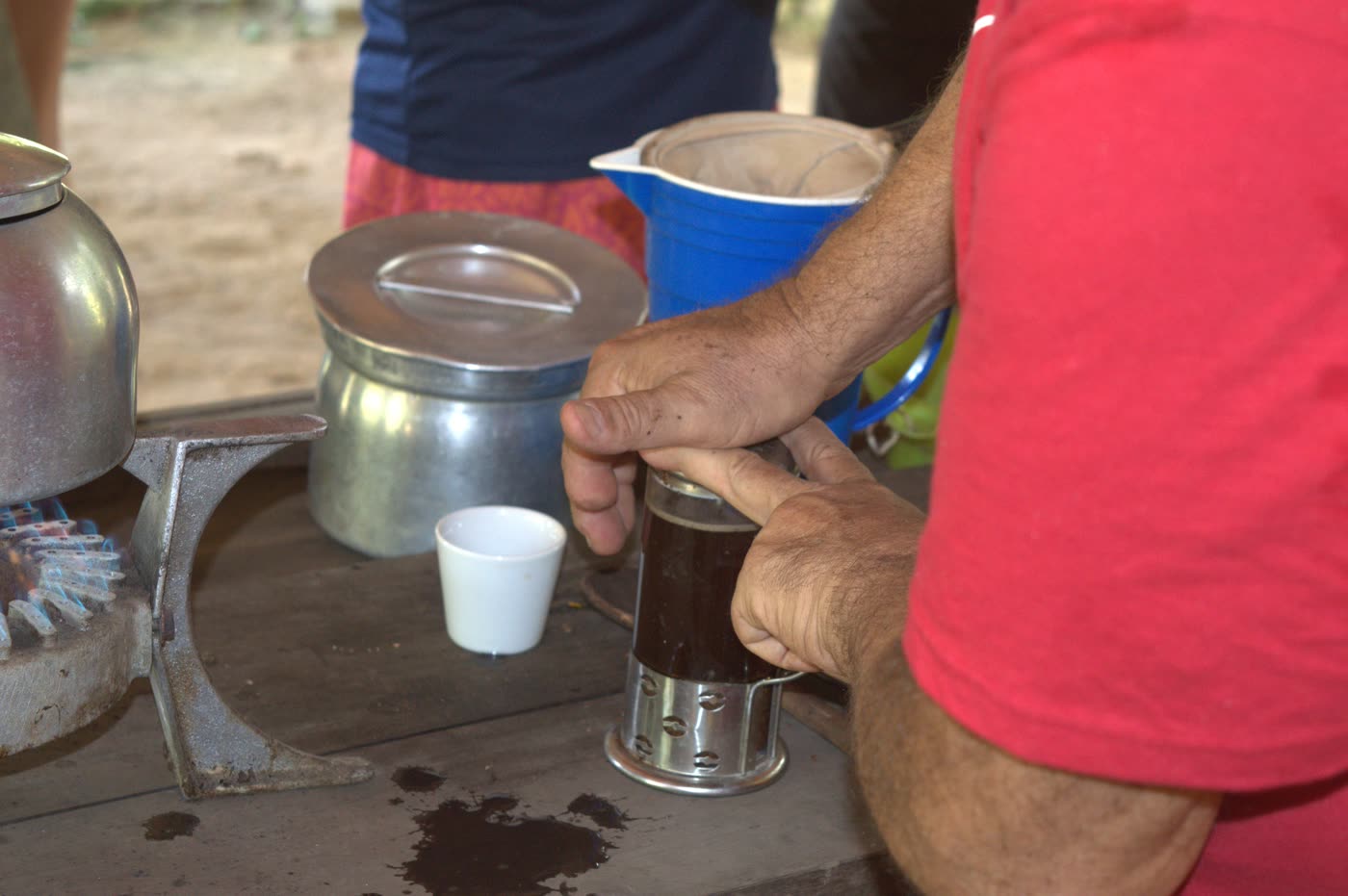 Café coado pronto na prensa, sobre a mesa de madeira