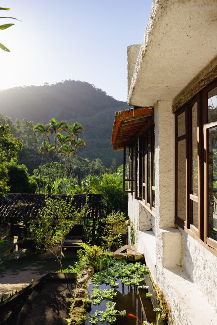 Casa-sede da fazenda com vista para a montanha da Mata Atlântica e o laguinho de peixes